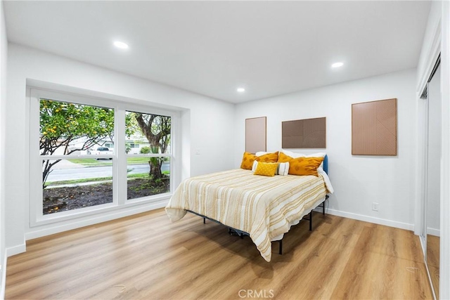 bedroom featuring light wood finished floors, baseboards, and recessed lighting