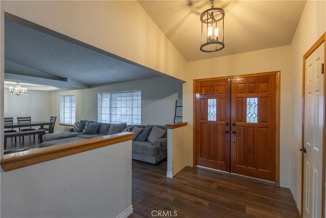 19200 Haida Rd, Apple Valley, CA 92307 - entryway featuring vaulted ceiling, dark wood-style flooring, a textured ceiling, and an inviting chandelier