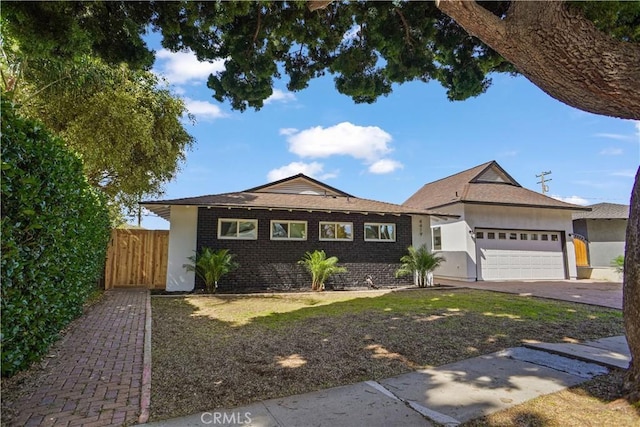 single story home with an attached garage, driveway, fence, and brick siding