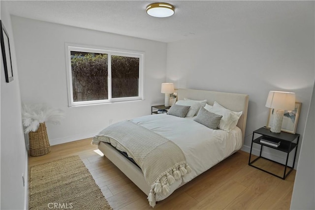 bedroom with wood finished floors and baseboards