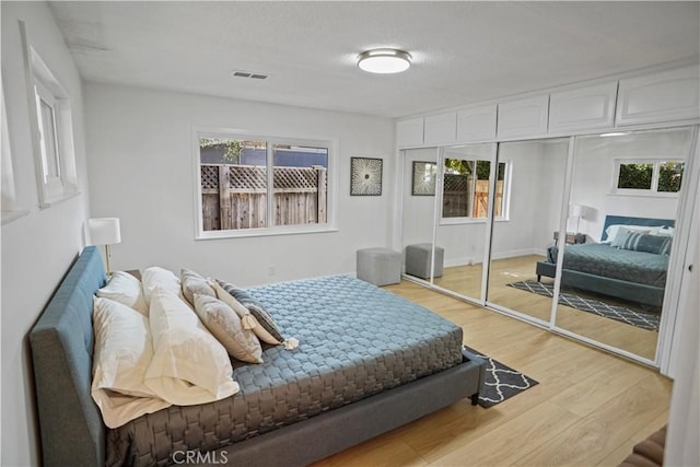 bedroom featuring light wood-style flooring and visible vents