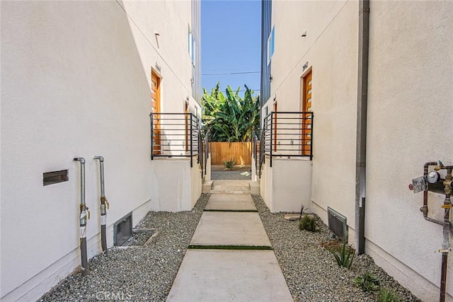 view of side of property with fence and stucco siding