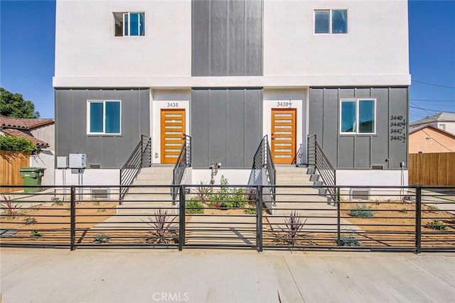 view of front facade featuring board and batten siding, entry steps, a gate, and a fenced front yard