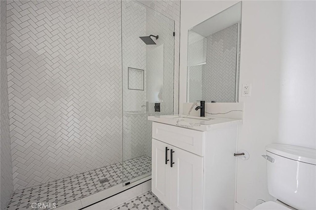 full bathroom featuring a stall shower, vanity, and toilet