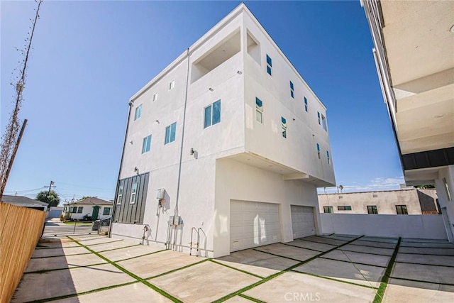 view of building exterior with a garage and fence