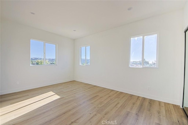 unfurnished room featuring light wood-type flooring and baseboards