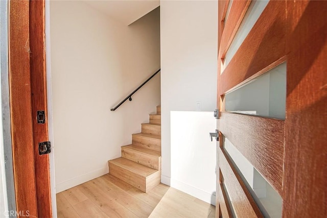 staircase with wood finished floors and baseboards