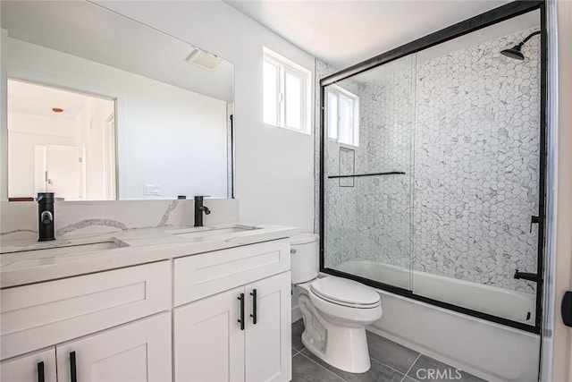 full bath with tile patterned flooring, a sink, toilet, and bath / shower combo with glass door