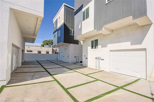 view of side of home with a garage and stucco siding