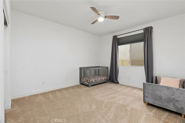 carpeted bedroom with ceiling fan and baseboards