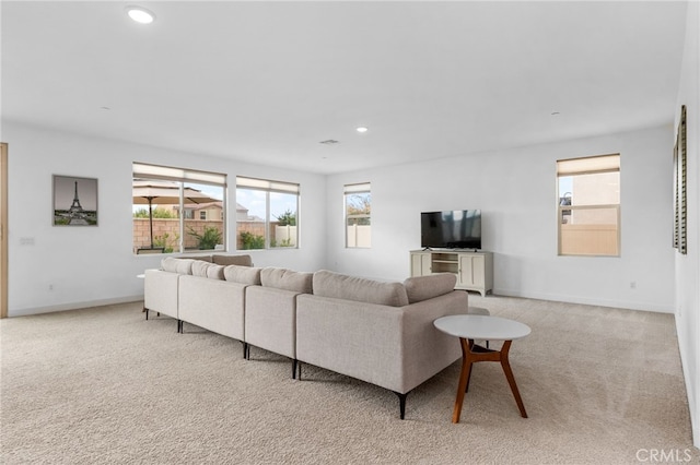 living room with recessed lighting, light colored carpet, and baseboards