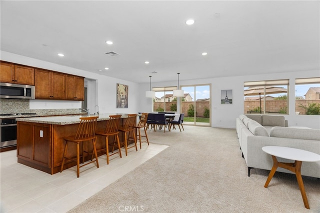 kitchen featuring recessed lighting, visible vents, stainless steel microwave, and stove