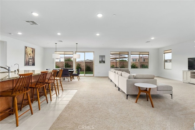 living room with light colored carpet, recessed lighting, a healthy amount of sunlight, and visible vents