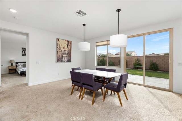 dining space featuring light carpet, baseboards, and visible vents