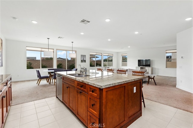 kitchen featuring visible vents, dishwasher, light colored carpet, a breakfast bar area, and a sink