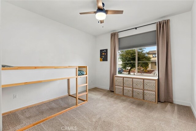 bedroom with a ceiling fan, baseboards, and carpet flooring