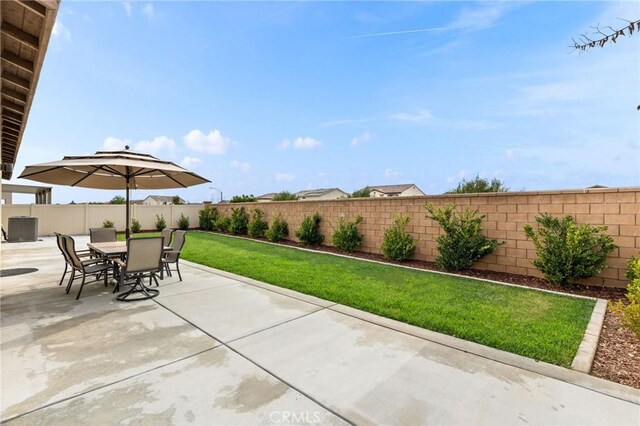 view of patio featuring central AC unit, outdoor dining area, and a fenced backyard