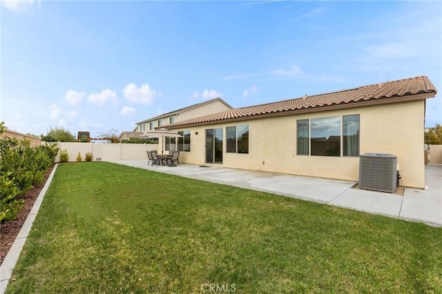 back of property with a patio, a fenced backyard, a yard, central AC, and stucco siding