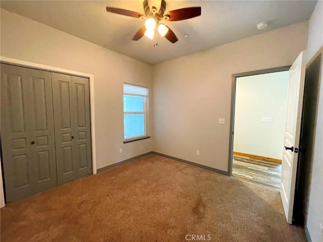 unfurnished bedroom featuring carpet floors, a closet, ceiling fan, and baseboards