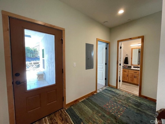 entryway with light wood-style flooring, electric panel, and baseboards