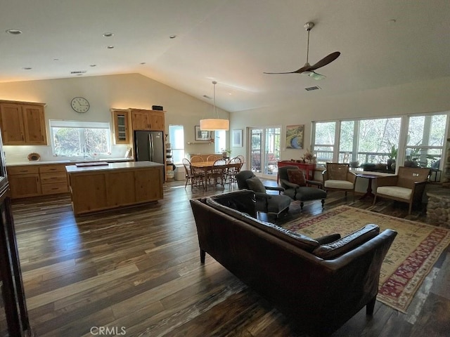 living room with ceiling fan, high vaulted ceiling, and dark wood-style flooring