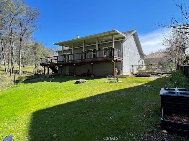 back of house featuring a fenced backyard, a deck, and a yard