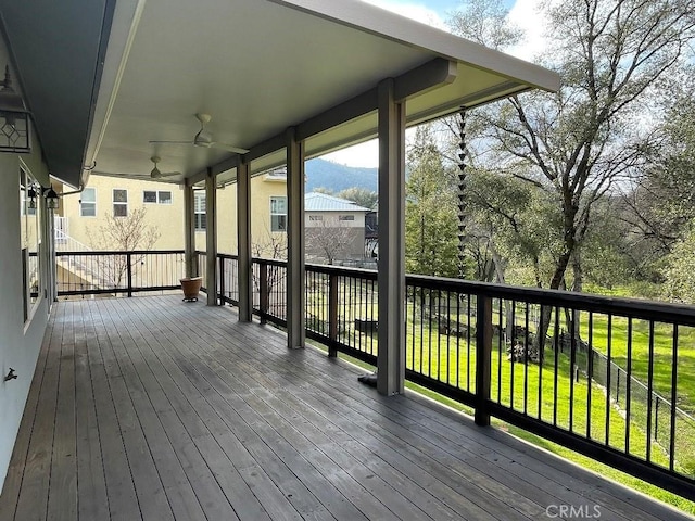 deck featuring ceiling fan and a yard