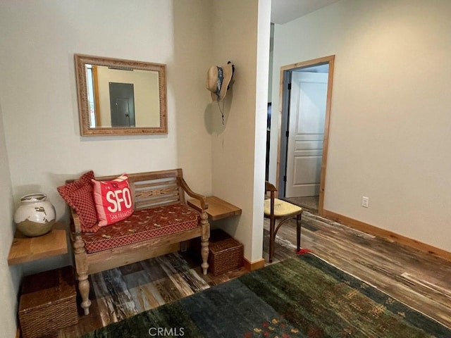 sitting room with electric panel, baseboards, and wood finished floors