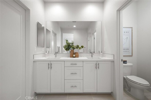 full bath with double vanity, a sink, and toilet