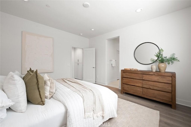 bedroom featuring baseboards, wood finished floors, and recessed lighting