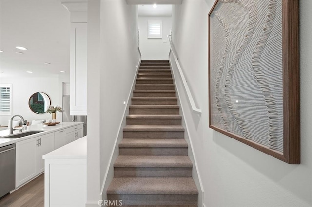 stairs featuring baseboards, wood finished floors, and recessed lighting