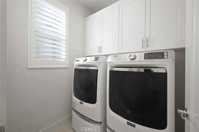 clothes washing area with cabinet space, baseboards, and independent washer and dryer