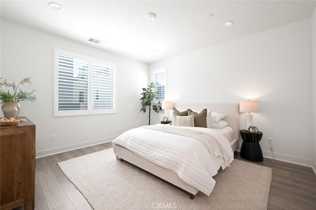 bedroom with baseboards, visible vents, wood finished floors, and recessed lighting