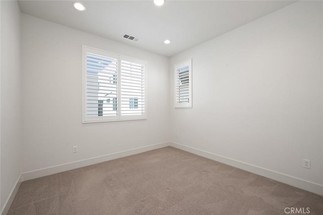 empty room with recessed lighting, visible vents, light carpet, and baseboards