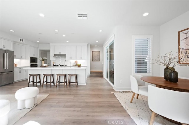 interior space featuring light wood-style flooring, visible vents, and recessed lighting