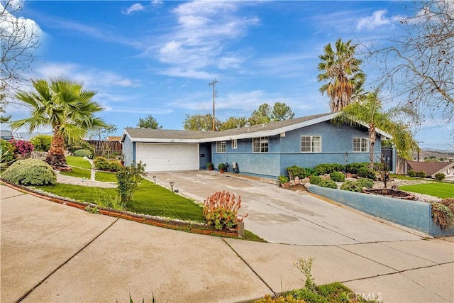 ranch-style house with an attached garage, driveway, a front yard, and stucco siding