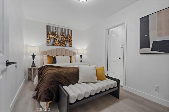 bedroom with wood finished floors and baseboards