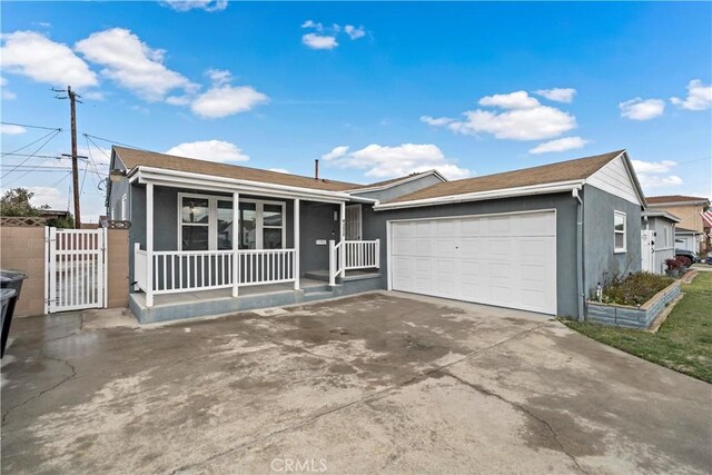 ranch-style house featuring stucco siding, a porch, a gate, a garage, and driveway