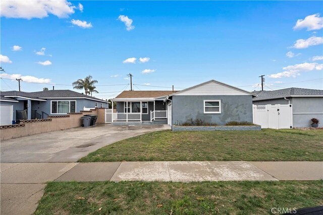 ranch-style house featuring driveway, a sunroom, fence, and a front yard