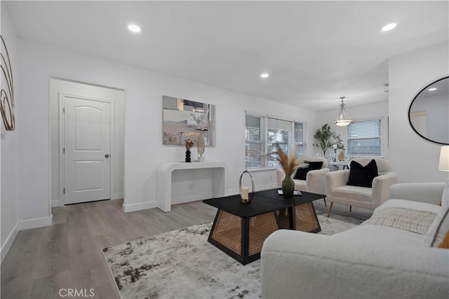 living area featuring baseboards, light wood-type flooring, and recessed lighting