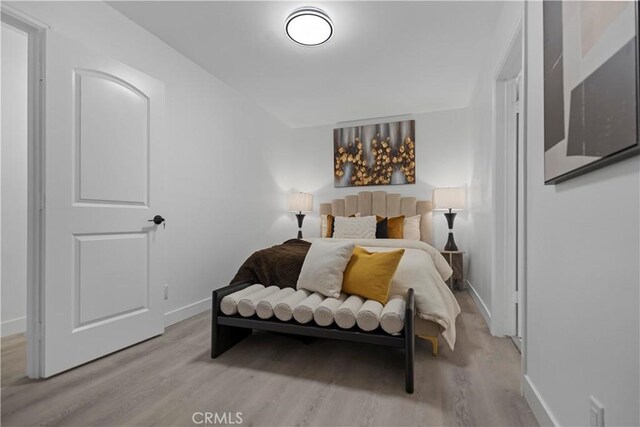 bedroom with light wood-type flooring and baseboards