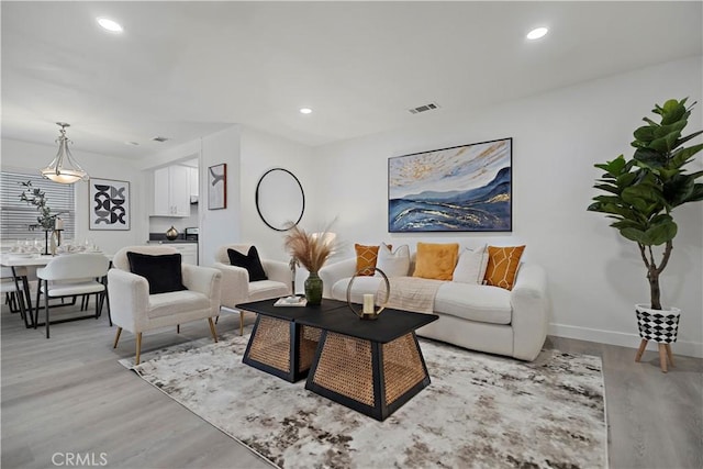 living area featuring light wood finished floors, visible vents, and recessed lighting