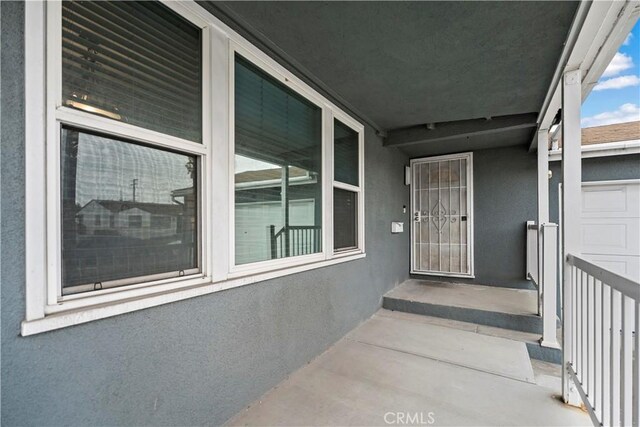 doorway to property with a garage and stucco siding