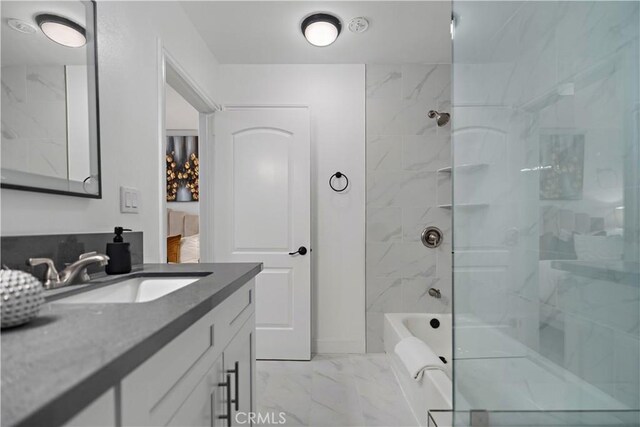 full bathroom featuring marble finish floor and vanity