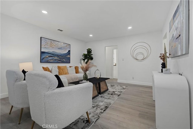 living area featuring recessed lighting, visible vents, baseboards, and wood finished floors