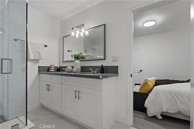 full bathroom featuring marble finish floor, vanity, a stall shower, and ensuite bathroom