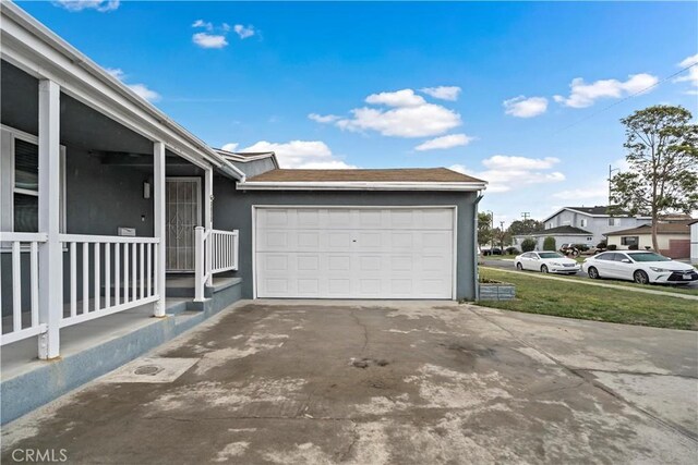 garage featuring a residential view and concrete driveway