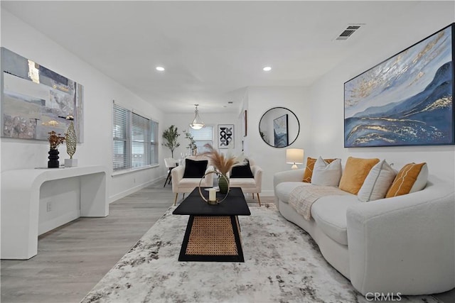 living area with recessed lighting, visible vents, baseboards, and wood finished floors