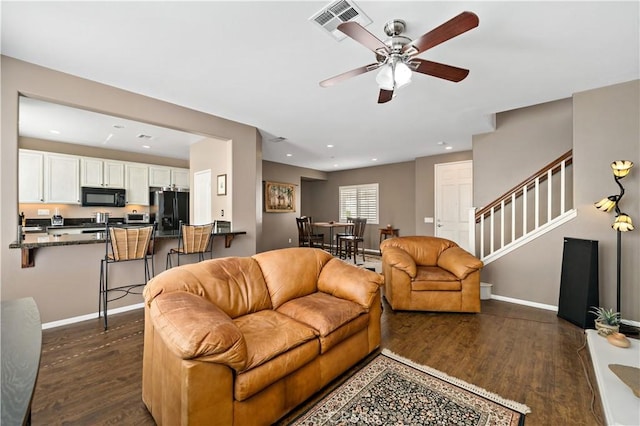 living room featuring visible vents, stairs, baseboards, and dark wood-type flooring