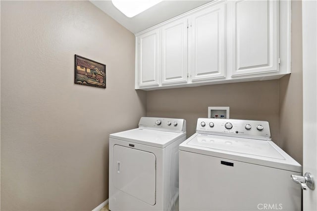 clothes washing area featuring cabinet space and washing machine and clothes dryer